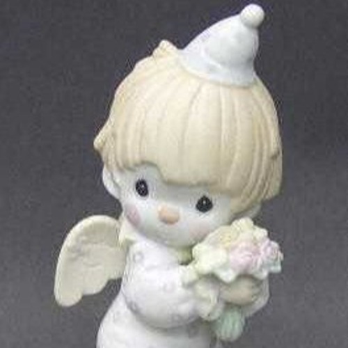 a porcelain angel figurine in a pointed cap holding flowers